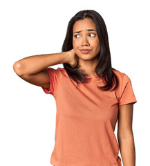 Young Filipina with long black hair in studio touching back of head, thinking and making a choice.