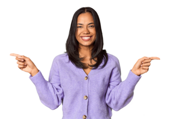 Young Filipina with long black hair in studio pointing to different copy spaces, choosing one of them, showing with finger.