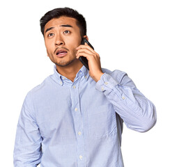 Chinese man engaged in a phone conversation in studio background