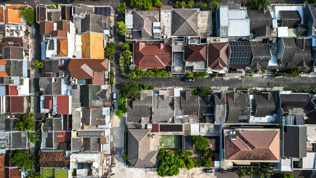 Aerial view of Solo City with crowded and dense housing buildings in morning sunlight. Surakarta cityscape urban landscape. Population density is displacing agricultural land and forests.