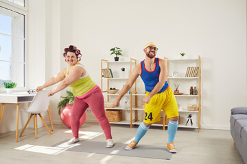 Funny couple of man and woman doing fitness exercises together at home. Ridiculous plus size woman...
