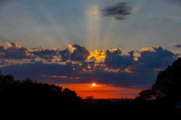 Orange sunrise on the horizon with emphasis on the sun's rays and birds in the distance. Idyllic Setting