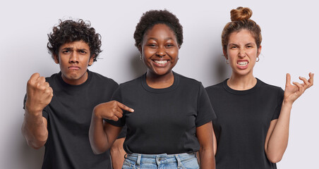 Positive dark skinned woman points at mock up space of casual t shirt shows place for your...