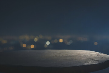 a rock table top with a blurred night cityscape background