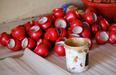 An Potter applies colour to earthenware oil pots or diyas at a workshop, ahead of the forthcoming Diwali festival, the Hindu festival of lights.