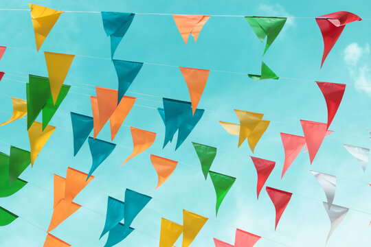 Fair flag bunting colorful background hanging on blue sky for fun fiesta party event, summer holiday farm feast celebration, carnival festival event, park or street festa design decoration