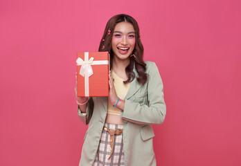 Happy beautiful Asian teen woman smile with red gift box isolated on pink background. Teenage girls in love, Receiving gifts from lovers. Christmas and Valentines Day concept. - obrazy, fototapety, plakaty