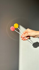 woman hand with yellow and red lollipop isolated