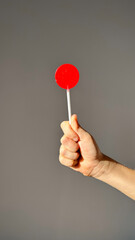 children's hand with red lollipop isolated