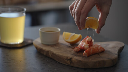 Man serve crab leg with pesto sauce with ginger beer on background