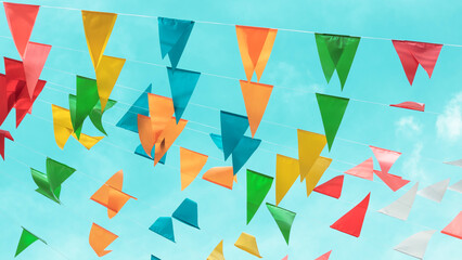 Fair flag bunting colorful background hanging on blue sky for fun fiesta party event, summer...