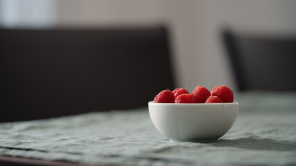 Fresh raspberries in bowl on linen napkin