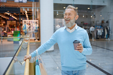 Handsome senior man going shopping at store
