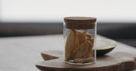 freeze dried mango in glass jar on olive wood board
