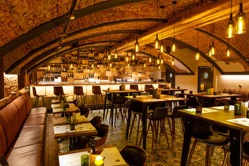 Interior of cozy modern restaurant with a bar counter and lamp lighting