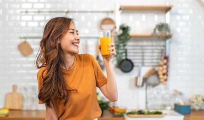 Portrait of beauty healthy asian woman making orange fruit smoothie with blender.girl preparing...