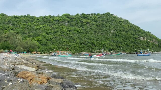 Pran buri, Thailand - Fishing boats floating on ocean rocky seashore near mountain forest outdoor summer nature blue sky.