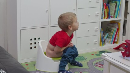 toddler child little boy sitting on a potty watching TV