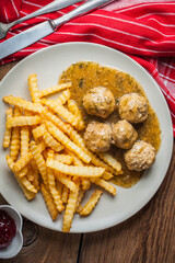 Meatballs with french fries in dill sauce.