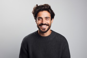 Fototapeta premium Portrait of a smiling man in his 30s dressed in a warm wool sweater against a white background. AI Generation