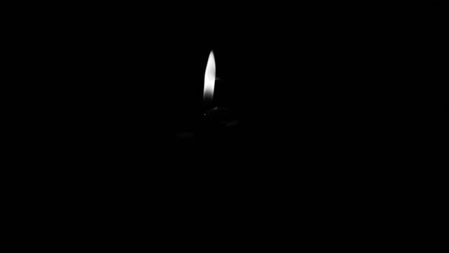 set off fireworks: hand lighting fuse with lighter, monochrome UHD 600fps horizontal video