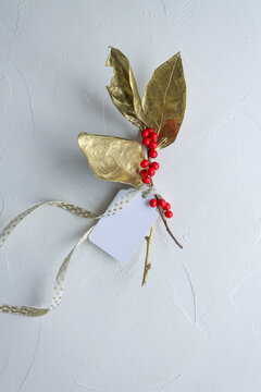 Golden christmas decoration on white background, with paper tag