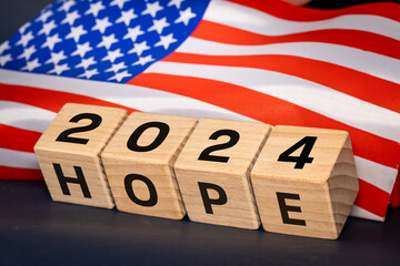 USA flag and wooden blocks with the symbol of 2024 and the word Hope, Beautiful navy blue...