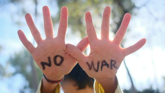 Child's hands open, bearing the message 'No to War.' Anti-war, pacifism, against arms sales, and violence prevention. Symbolizing victims of war, especially civilians and children. Embracing Peace Day