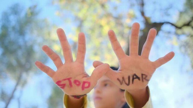 The delicate openness of a child's hands carries a powerful message: 'Stop war.' This expression encapsulates anti-war sentiments, a commitment to pacifism, opposition to arms sales.