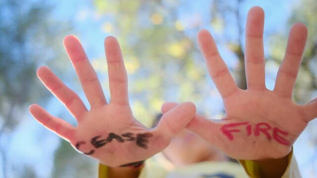 The hands of a child gently reveal the message 'Cease Fire,' echoing a strong anti-war sentiment. Advocating against arms sales, embracing pacifism, and championing violence prevention. Symbolizing.