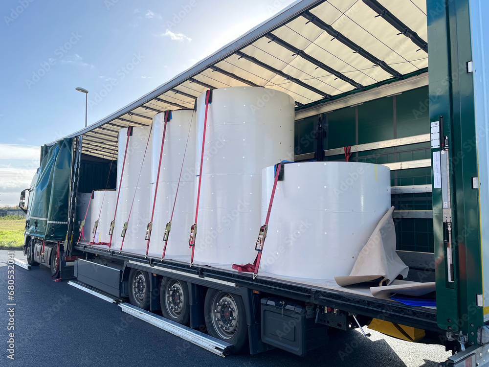 Wall mural loading, transporting and unloading large rolls of paper in a semi-trailer. securing cargo with stra