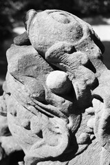 A closeup of the face of an ancient fu dog in black and white.
