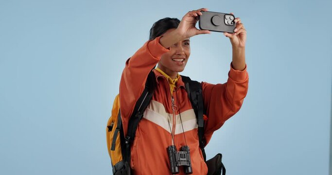 Woman, phone and backpack for photography, travel or memory of adventure against a studio background. Female person, hiker or tourist taking picture or live streaming with mobile smartphone on mockup