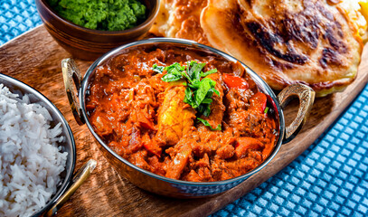 Butter chicken with rice and naan bread served in karahi pots