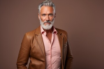 Fototapeta premium Portrait of a glad man in his 50s sporting a stylish leather blazer against a pastel brown background. AI Generation