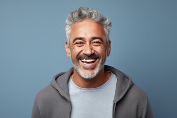 Portrait of a joyful man in his 50s wearing a zip-up fleece hoodie against a pastel gray background. AI Generation