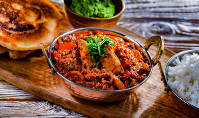 Butter chicken with rice and naan bread served in karahi pots
