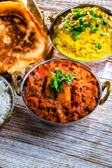 Butter chicken with rice and naan bread served in karahi pots