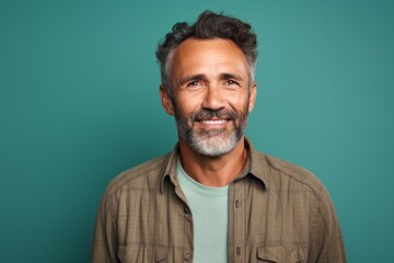 Fototapeta premium Portrait of a glad man in his 60s wearing a comfy flannel shirt against a soft teal background. AI Generation