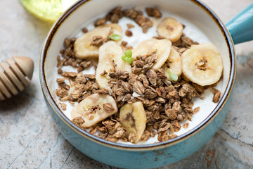 Turquoise serving bowl with greek yogurt, granola and banana chips, close-up, horizontal shot, selective focus