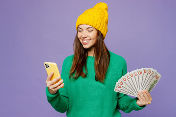 Young woman she in green sweater yellow hat casual clothes hold fan of cash money in dollar...
