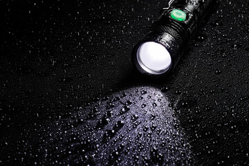 Flashlight water resistant in drops on black background