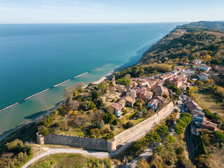 Italy, November 19, 2023 - aerial view of the small medieval village of Fiorenzuola di Focara immersed in the San Bartolo park in the province of Pesaro and Urbino in the Marche region
