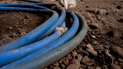 Blue hose reel on the ground. Used to water flowers and plants