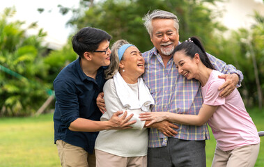 Obraz premium Portrait enjoy happy smiling love multi-generation asian big hug family.Senior mature father and elderly mother with young adult woman and son outdoor in park at home.insurance concept