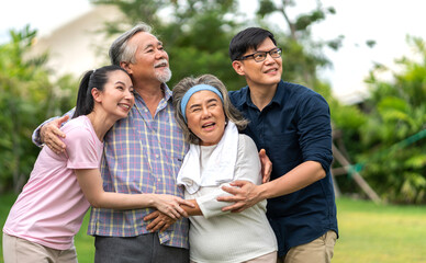 Obraz premium Portrait enjoy happy smiling love multi-generation asian big hug family.Senior mature father and elderly mother with young adult woman and son outdoor in park at home.insurance concept