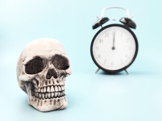 skull and alarm clock on a blue background 