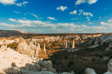 The vast landscape of Cappadocia unfolds under a vibrant sky, where the famed fairy chimneys rise...