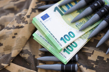 Bundles of euro bills and a machine gun belt on the camouflage uniform of a Ukrainian soldier....