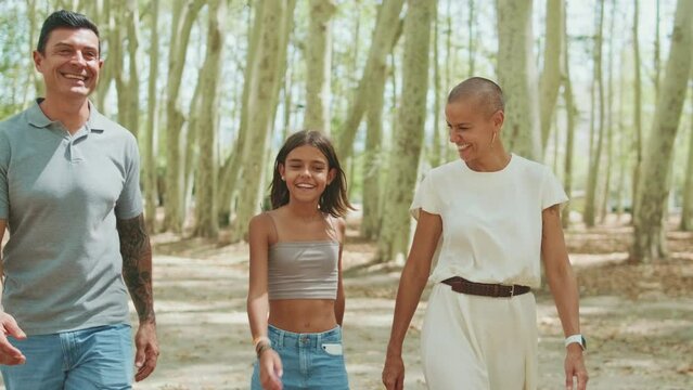 Happy family spending time together talking and walking in the city park